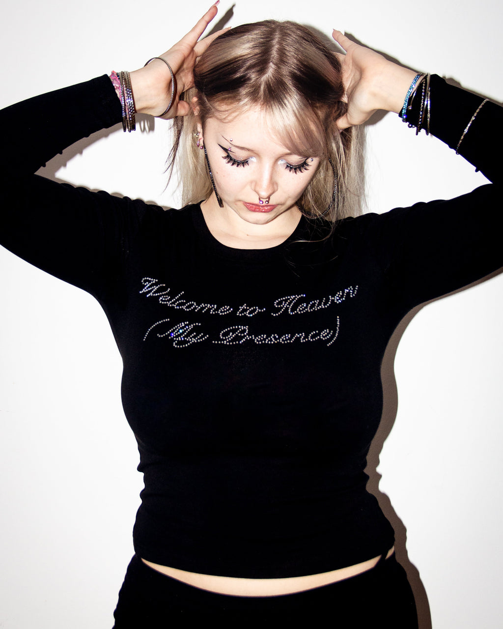 Person wearing a black sweatshirt with text, posing against a white background