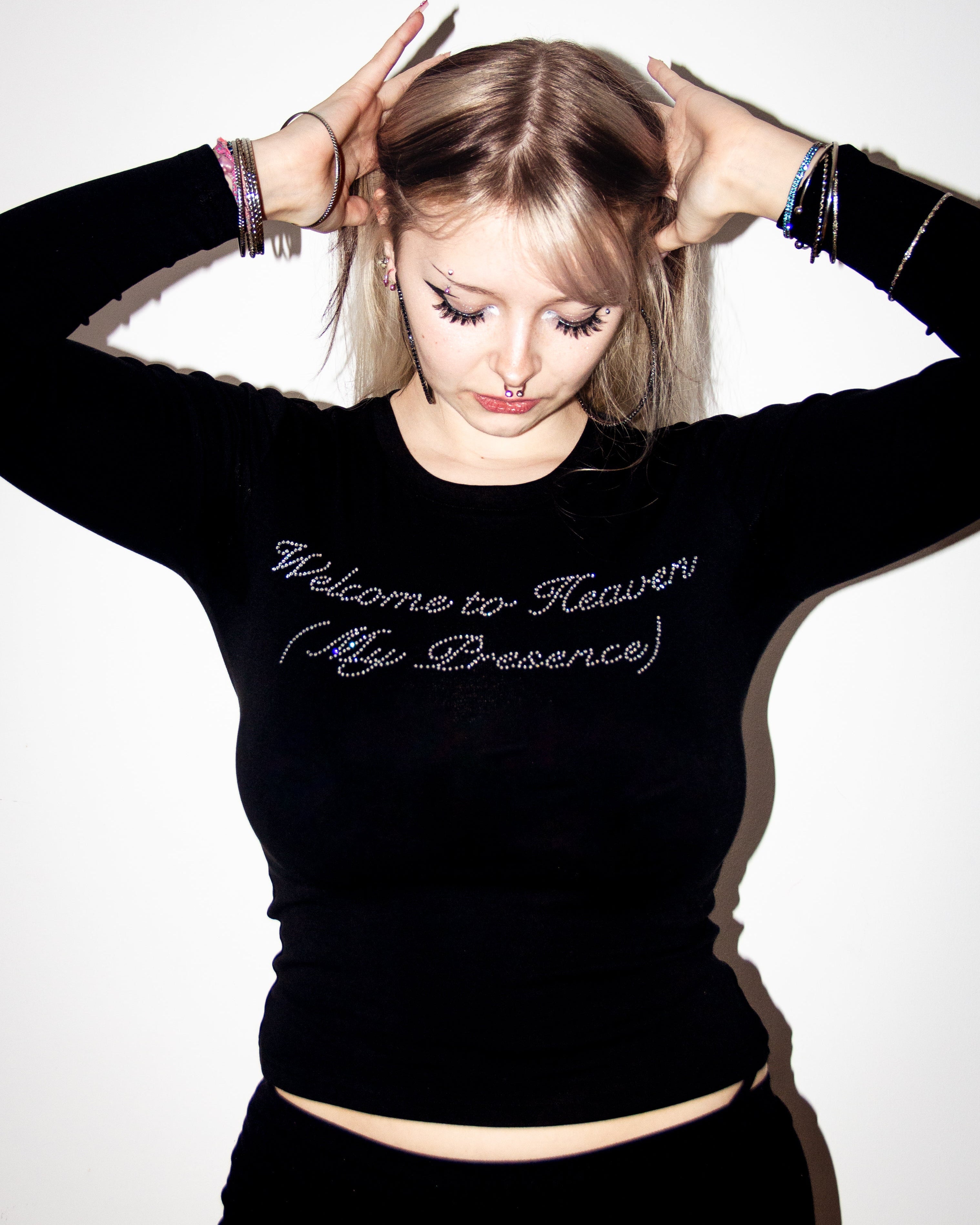 Person wearing a black sweatshirt with text, posing against a white background